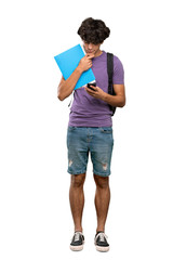 A full-length shot of a Young student man thinking and sending a message over isolated white background