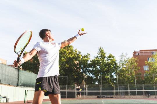 Young Man Playing Tennis Outdoors.