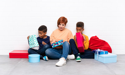 African American kids with their mother among many gifts for christmas holidays