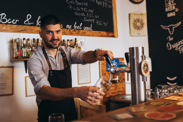 bartender pours beer in bar