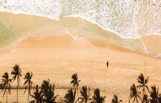Aerial photo of a surfer on a beach in Hawaii