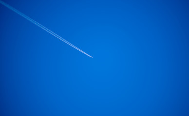 avión con estela en cielo azul