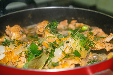 Meat with onions, carrots, dill and Bay leaf is stewed in a saucepan. Home cooking. Close up.
