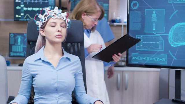 Female sitting on a chair with brainwaves scaner headset