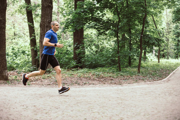 Man training and running in the forest or urban park