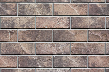 Brown stone siding tile wall abstract background. House exterior with blocks. Crafted outer wall