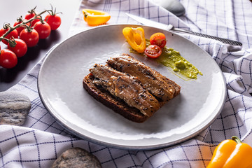 Homemade smoked herring sandwich with rye bread on light grey plate, top view 