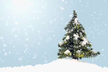 christmas tree on fake snow with copy space on blue background.