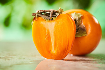 selective focus of whole and cut persimmons on marble surface