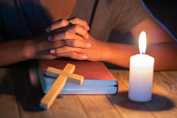 Religious Christian Child  praying over Bible indoors, Religious concepts