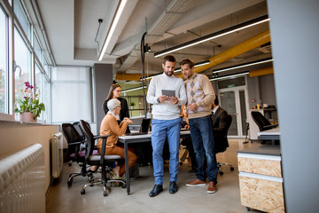 Fototapeta na wymiar Two businessmen with a digital tablet in the modern office