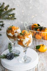 Citrus trifle with fresh tangerines. Christmas portioned dessert on the festive table.
