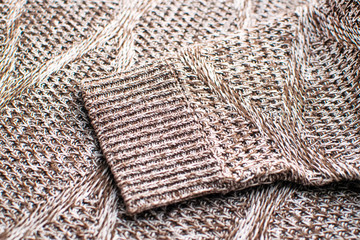 Knit texture of brown wool knitted fabric with cable pattern as background. Knitted brown sweater.