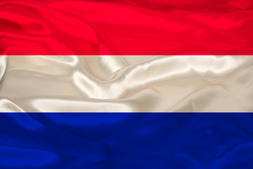 beautiful photo of the colored national flag of the modern state of the Netherlands on textural fabric, concept of tourism, emigration, economics and politics, closeup