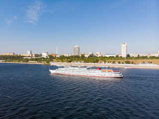 A cruise ship with tourists passes by the central embankment of Volgograd, goes down the Volga to Astrakhan. Volgograd. Russia