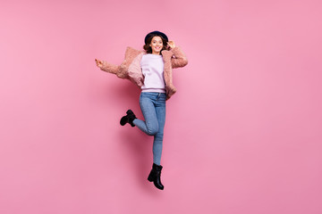 Full body photo of amazing funny model millennial lady jumping high tourist abroad rejoicing wear stylish fluffy jacket retro hat jeans boots isolated pink background