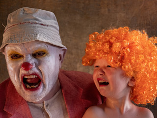 Evil clown and child dressed up as girl in bright clothes. kid does not like clown too made up and does not recognize his father in him. man changes clothes at home for holidays and weekends by clown