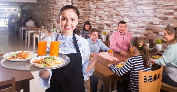 Smiling Waitress Warmly Welcoming Guests To Family Cafe