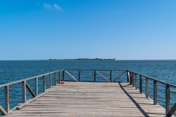 Fototapeta na wymiar Wooden pier bridge on sunny summer day in amazon with beautiful waters of Tapajos River in the city of Santarem, Para, Brazil.Travel, tourism, wanderlust, climate change and conservation concept.