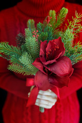 Woman wear red sweater hold christmas flower bouquet.