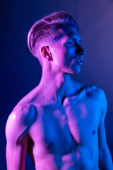 Handsome pumped up guy with naked torsos. Sports guy, attractive male body. Studio shooting with color filters