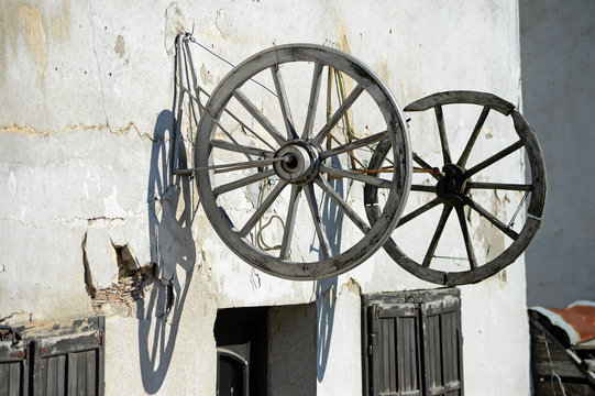  The wheels of the old carriage hung on the wall of the old house.
