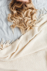 cropped view of blonde woman lying on bed