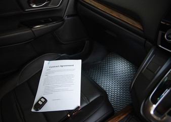 White paper contract document detail with luxury pen and empty space for authorized signature on sitting seat inside modern car