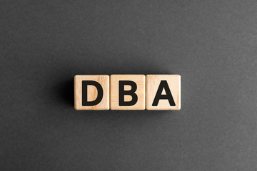 DBA - acronym from wooden blocks with letters, DataBase Administrator or doing business as...
