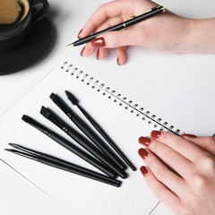 Hands with a set of Flatley brushes. Eyebrow and makeup brushes on white background.