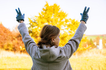 Woman raises both hands in the air