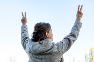 Woman raises both hands in the air