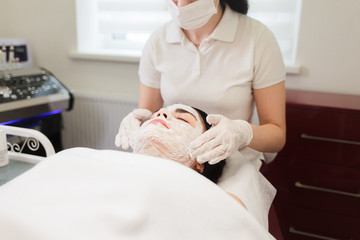 Obraz na płótnie Canvas Procedure for applying a moisturizing nourishing mask to the face in a beauty salon