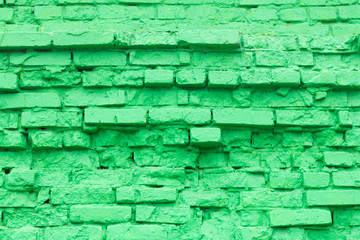 Green brick background texture of old brick masonry with elements of destruction, painted in green color