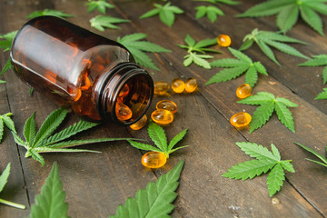 CBD oil capsules and hemp leaves