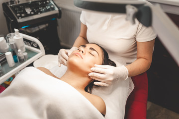 Obraz na płótnie Canvas Cosmetologist massages the client's face
