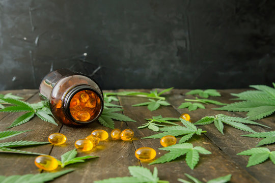 Medicinal CBD oil capsules and hemp leaves