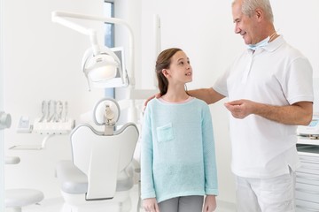 Dentist talking to child patient in clinic 