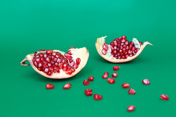 Ripe organic pomegranate fruit isolated on green background.