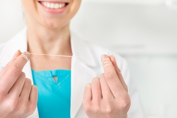 Dentist holding dental floss in clinic