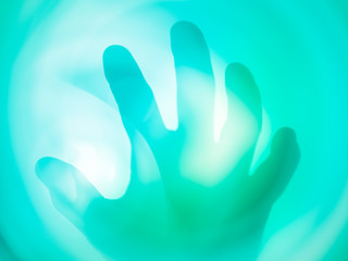 Naklejka na ściany i meble Abstract turquoise and green spots a shadow of hands, blurred background.