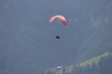 a man flies with a paraglider over the Alps of Trentino-Alto Adige