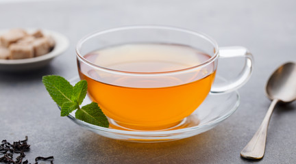 Tea cup with mint leaf. Grey background. Close up.
