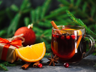 mug with traditional Christmas warm drink mulled wine with cranberries, cinnamon, anise and citrus