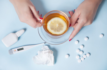 Woman holding cup of tea with piece of lemon. Health and traditional medicine concept