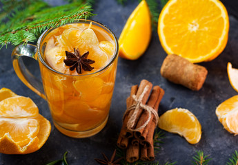 A tasty and creative Christmas cocktail or mulled wine with tangerines, cinnamon and anise
