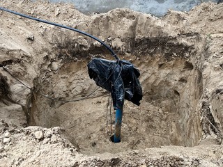 Drilling a well in the ground. A covered pipe comes out of the ground. Extraction of water from the earth.