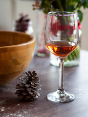 Vertical Still life wine in a glass on vintage wood table. Christmas or winter warming drink with pinecones around