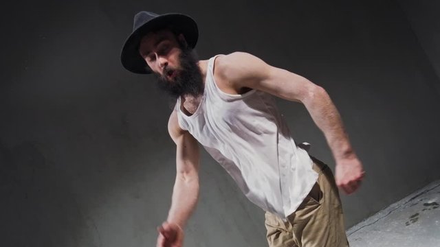 Man dancer showing break-dancing moves against colourful powder explosion