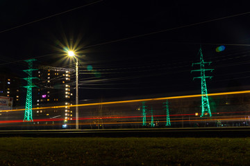 traffic in a night city past power lines